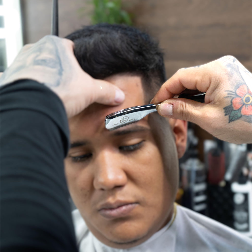 silver clutch straight edge barber razor for shaving in use