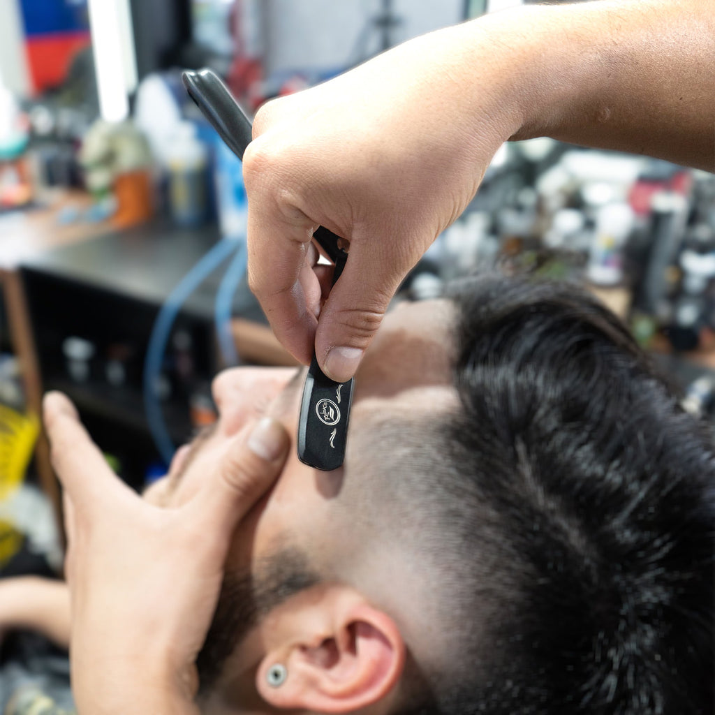 black clutch straight edge barber razor for shaving in use